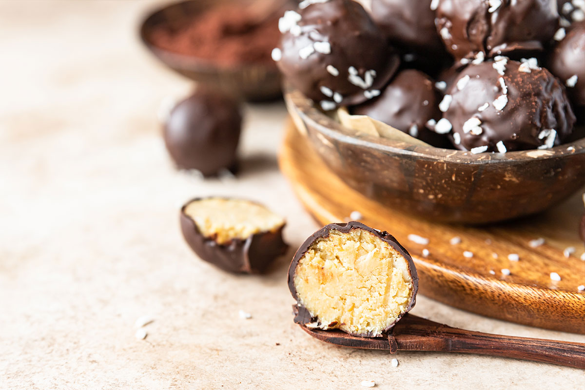 Peanut butter balls in chocolate glaze sprinkled with shredded coconut