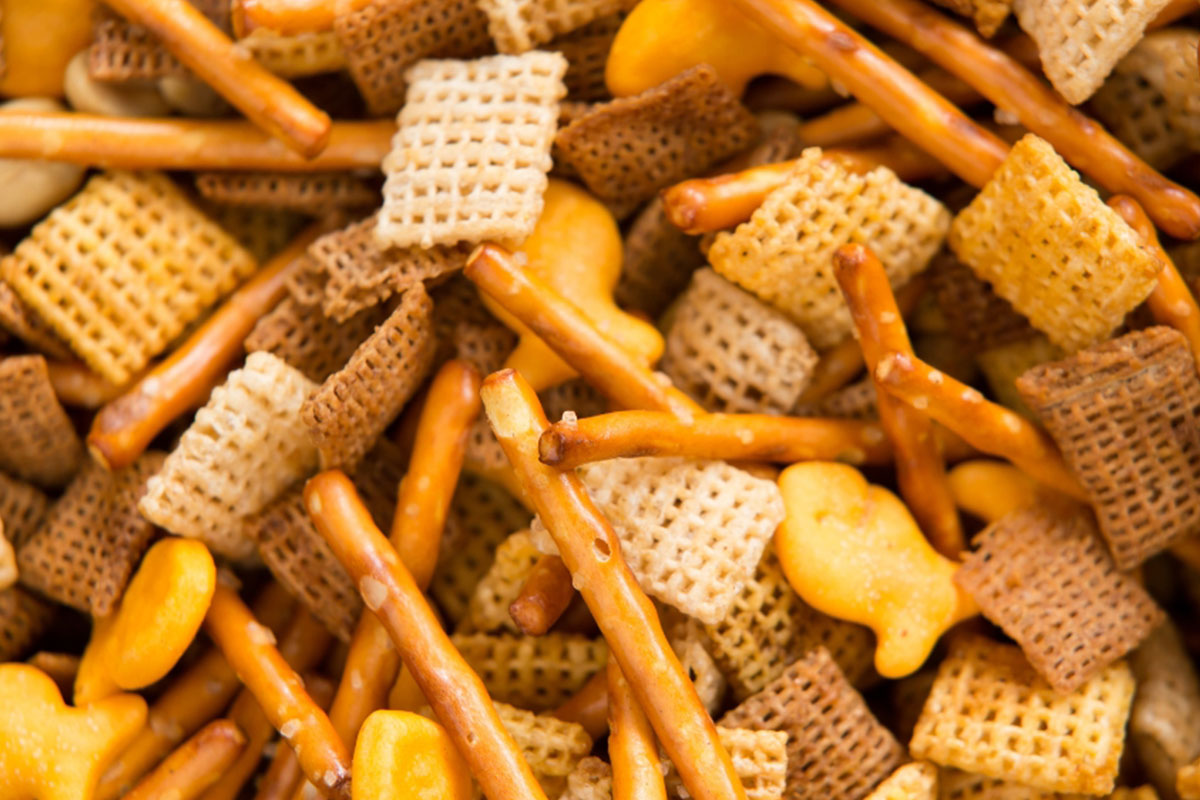 close up shot of a ranch snack mix containing pretzels, cereal and crackers